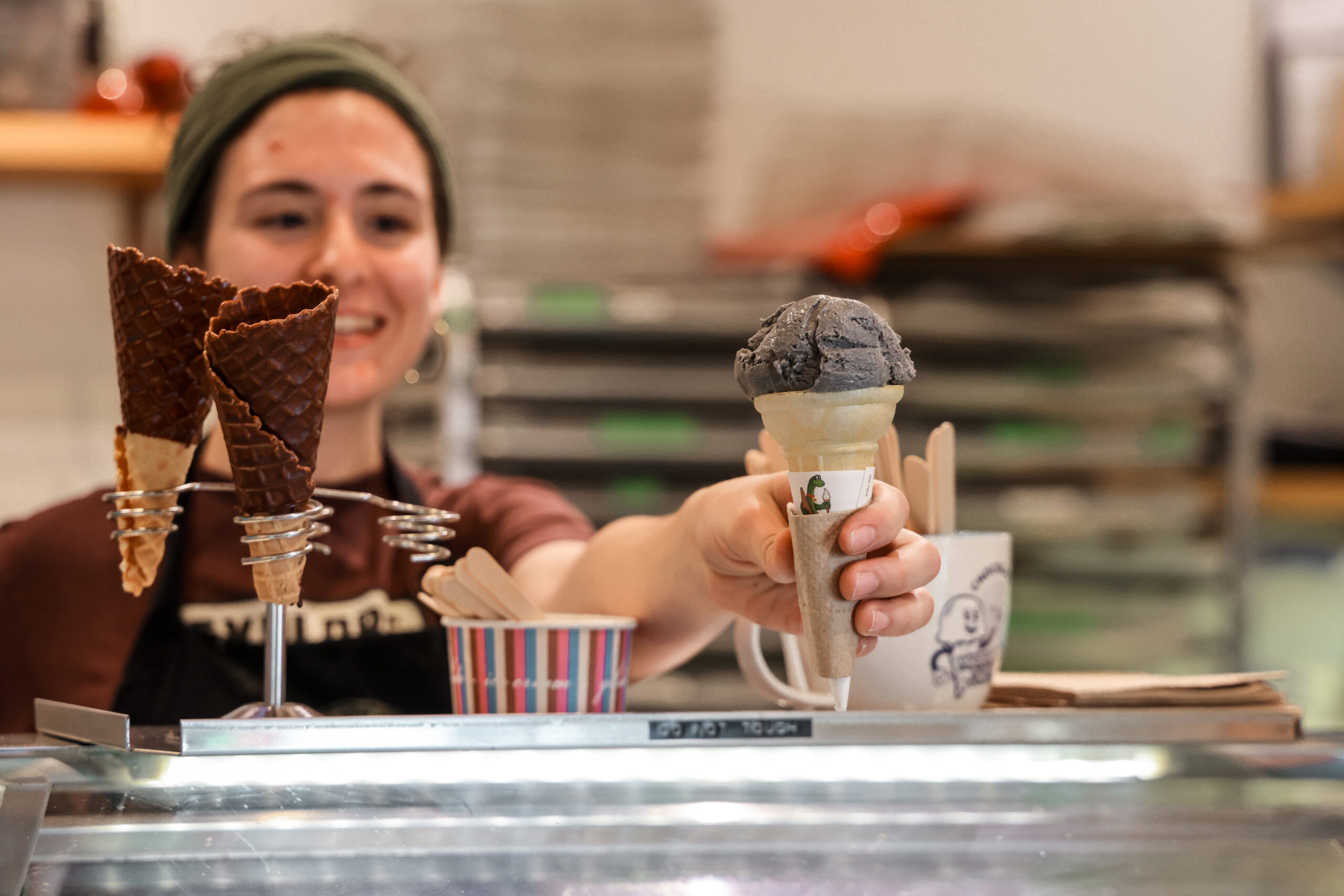 a woman holding up two ice cream cones