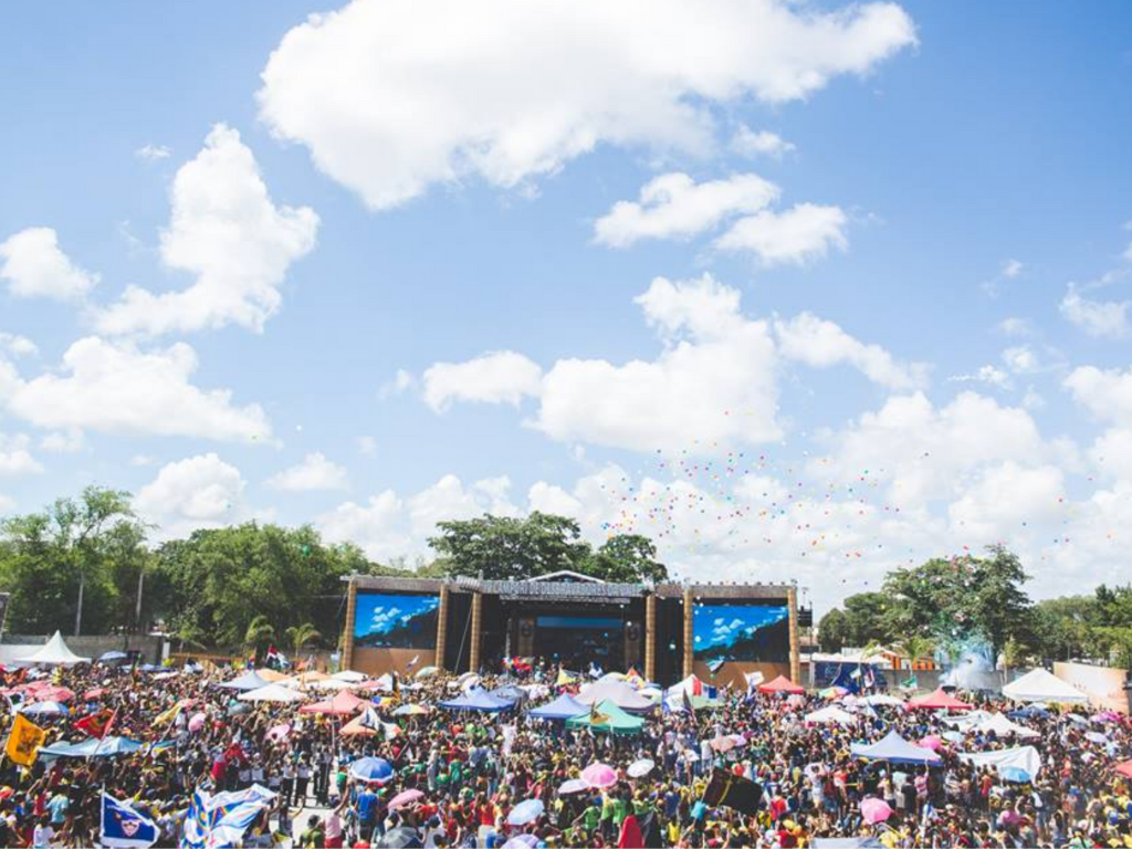 a stage in the background and a crowd of people in an outdoor setting.